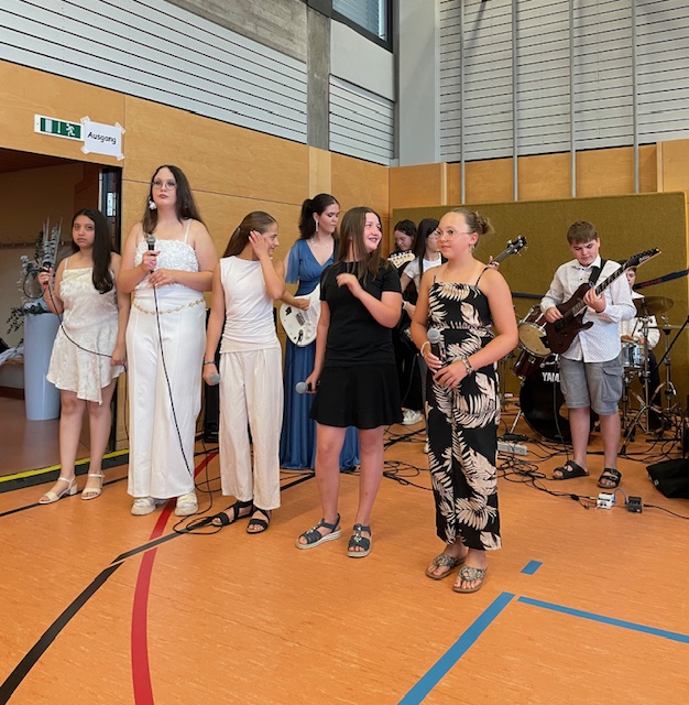 Schülerinnen und Schüler die eine Band bilden beim Musik spielen