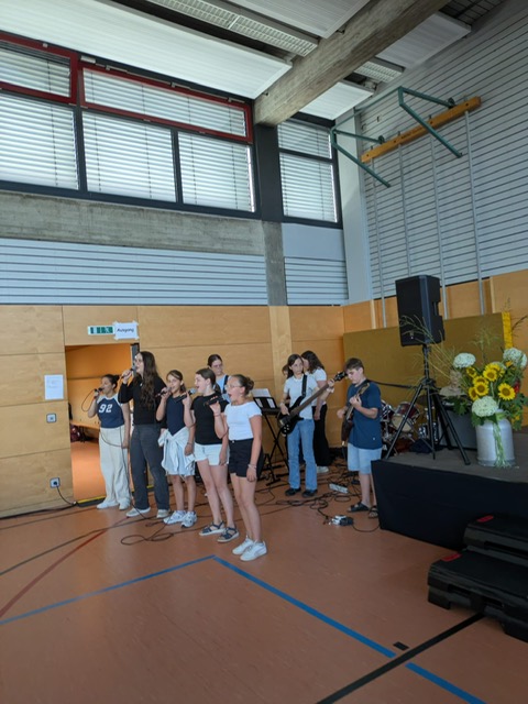 Schulband spielt einen Song neben der Bühne in der Turnhalle